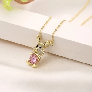 Close-up of a gold rabbit pendant with pink zircon and sparkling clear stones on an O-chain