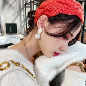 Detail shot of cute bunny ear earrings with faux pearls and orange knit headband