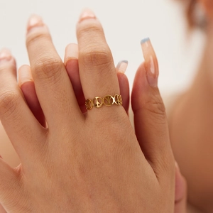 Minimalist gold stainless steel open ring featuring cutout peace signs on female finger