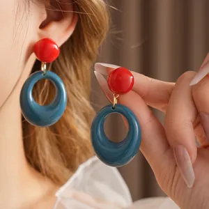 Retro geometric resin earrings featuring a red bead and navy blue oval hoop design