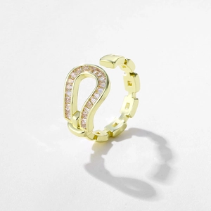 Detail of gold horseshoe ring with pink gemstones and geometric hollow chain band