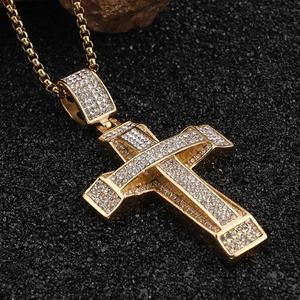 Macro shot of gold-plated hip hop cross pendant encrusted with sparkling rhinestones