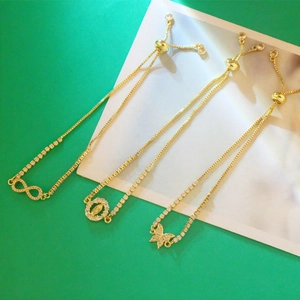 Detailed view of adjustable 18K gold-plated bracelets with infinity and butterfly charms