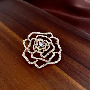 Exquise broche fleur plaquée or avec pétales évidés et incrustation de strass brillants