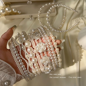 Close-up of elegant pearl headbands featuring various designs and white floral accents