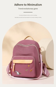 Detail of purple nylon backpack with embroidered rabbit pattern and yellow leather trim