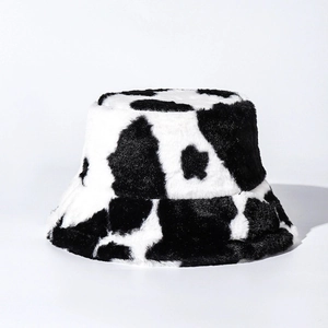 Winter plush bucket hat featuring a trendy black and white cow print pattern in soft faux fur