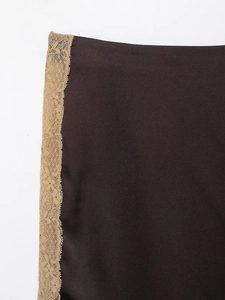 Close-up of smooth brown satin fabric with intricate champagne lace embroidery detail