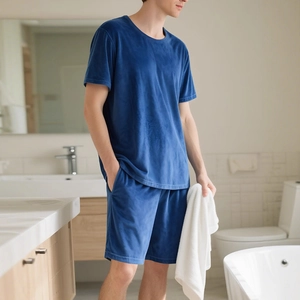 Men's navy blue velvet lounge set with short sleeves and shorts in a modern home setting