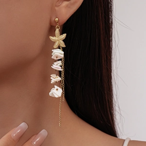 Golden starfish earrings with white shells and elegant metal chain tassels on model
