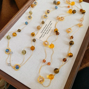Makroaufnahme der Vintage-Perlenkette mit bunten Kristallen und goldenen Kettendetails