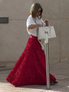 Detail of red evening skirt featuring 3D floral petal textures and voluminous long hem