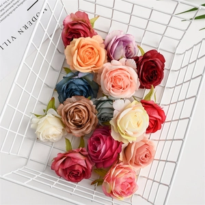 Close-up of colorful artificial silk rose heads in a white metal basket for wedding decor