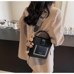 Detail of black leather bucket bag with retro wide strap and WEGOCO brand pocket