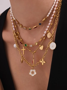 Detailansicht goldener Lagenhalsketten mit Zirkonias, Kreuz und Herzanhängern