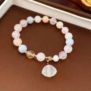 Detail of freshwater pearl and gemstone stretch bracelet with carved flower petal charm