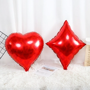 Close-up of heart and diamond shaped red foil balloons for casino themed party decor