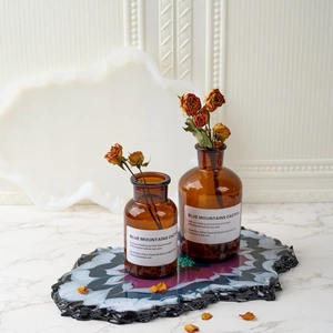 Irregular wave resin tray with black and purple marble effect on a marble table