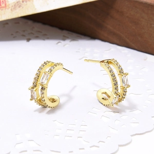 Detail of gold C-shaped earrings featuring double rows of clear cubic zirconia inlay