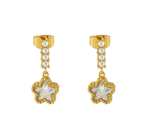 Detail view of gold drop earrings featuring white pearls and a crystal star pendant