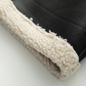 Detail shot of premium black leather texture and soft beige faux shearling lining trim