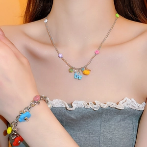 Detail of colorful elephant and floral charms on a stainless steel necklace and bracelet