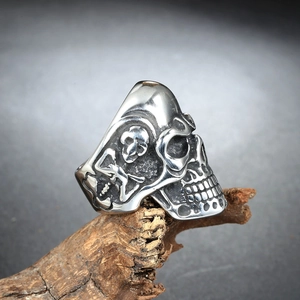 Gothic skull ring for men in stainless steel displayed on a natural wood stand