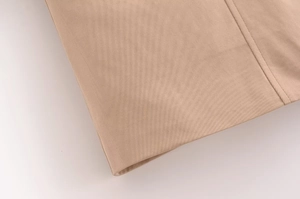 Dettaglio macro del tessuto twill kaki e delle cuciture della gilet senza maniche