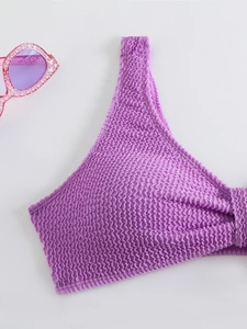 Detail of purple smocked bikini top featuring textured fabric and wide shoulder straps