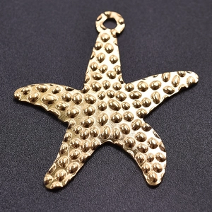 Macro detail of golden starfish pendant featuring a hammered 304 stainless steel texture