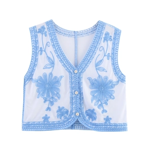Detail of floral embroidery on vintage white mesh vest with V-neck lace trim and buttons