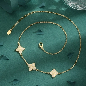 Elegant gold necklace featuring three sparkling clover pendants set with brilliant crystals