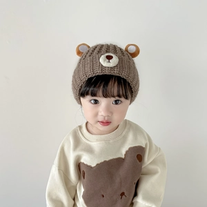 Detail of warm brown knit baby bear ear hat and ivory sweatshirt with bear print