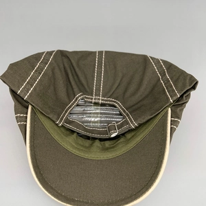 Detail view of military green newsboy hat showing white stitching and adjustable strap
