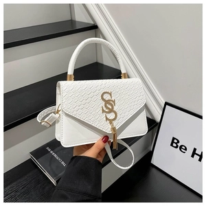 Detailed view of white crocodile pattern handbag with gold S-shaped buckle and metal fringe