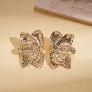 Detail of 18K gold plated flower earrings with etched petals and vintage metal texture