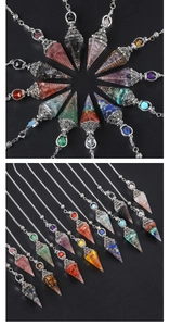 Multiple hexagonal crystal pendants with silver metal chains arranged on a dark background
