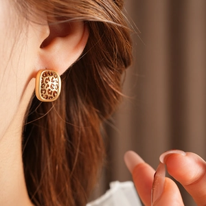 Gros plan d'une boucle d'oreille dorée à motif léopard ajouré sur l'oreille d'un mannequin