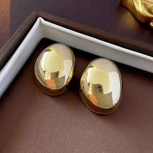 Macro shot of gold-plated oval bean stud earrings with high-polish metallic finish