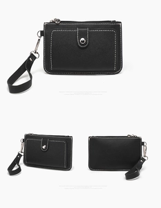 Detailed views of black lychee leather coin purse with white stitching and wrist strap