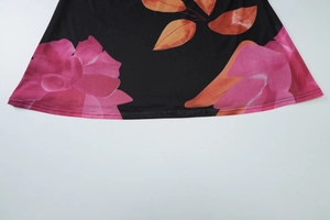 Detailansicht des Kleidsaums mit Blumenprint in Pink und Orange auf schwarzem Strick