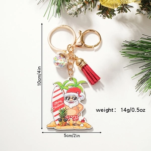 Cartoon Santa Claus surfing keychain with colorful tassels and a golden metal ring