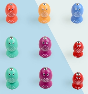 Close-up of colorful wooden magnetic fish toys with metal studs in grid layout