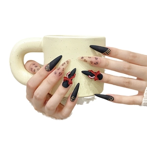 Elegante handgefertigte Stiletto-Kunstnägel in Mattschwarz mit roten Schleifen-Designs
