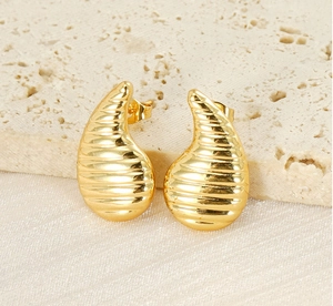 Détail de boucles d'oreilles goutte dorées 18K avec textures de vis horizontales