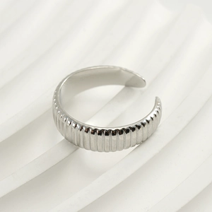 Macro shot of silver adjustable open ring featuring vertical grooved texture design