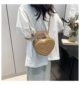 Detailansicht der khakifarbenen herzförmigen Handtasche mit 3D-Prägung und Goldbeschlägen