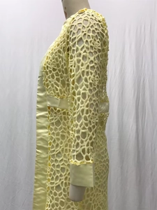 Détail du cardigan jaune crocheté à manches longues présenté sur un mannequin de profil