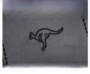 Close-up of black leather texture with embossed kangaroo logo and stitched detailing