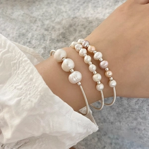 Detail of three-piece silver pearl bracelets set with white and purple baroque pearls